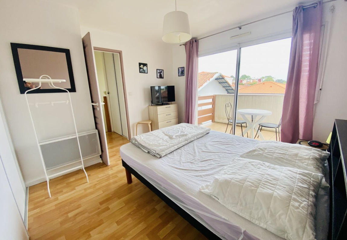 Terrasse équipée d’un store-banne et d’un salon de jardin, parfaite pour vos repas d’été