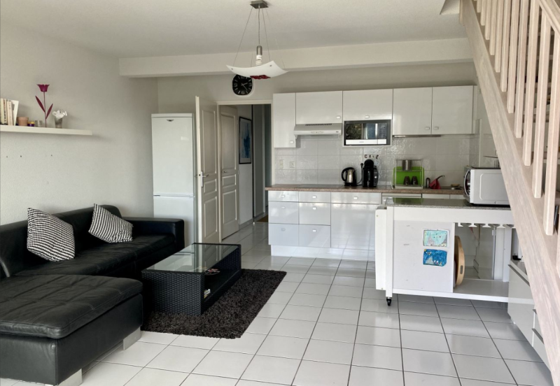 Séjour lumineux avec cuisine ouverte et espace salon convivial pour des vacances en famille réussies